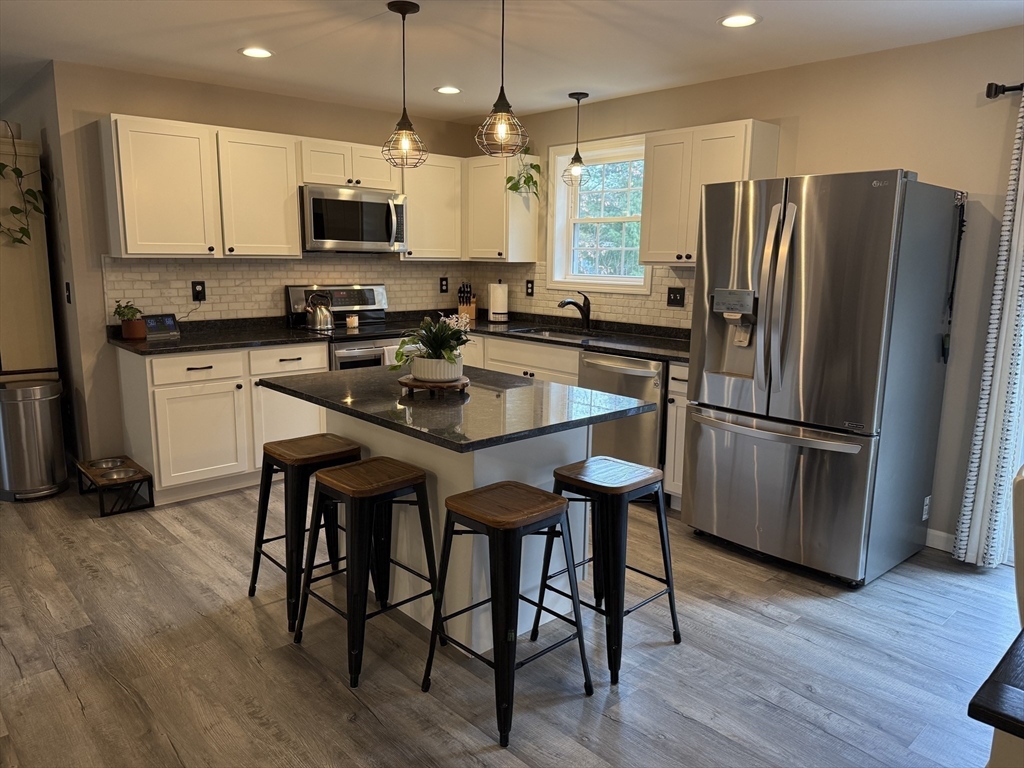 288 Chase Road Athol, MA 01331 - Photo 2 of 24 a kitchen with stainless steel appliances granite countertop a table chairs microwave and refrigerator