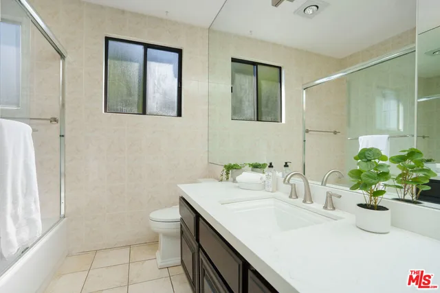 a bathroom with a sink a toilet and mirror