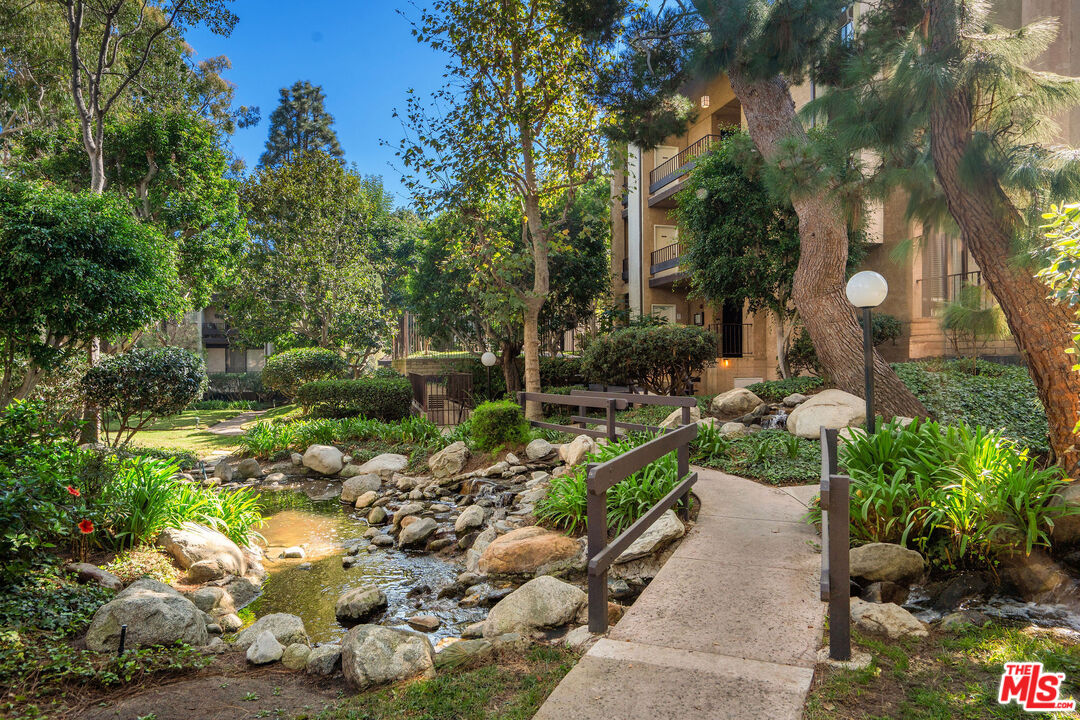 8114 Manitoba Street, Unit 208 Playa del Rey, CA 90293 - Photo 24 of 27 a garden with lots of trees and flowers and covered with wooden fence
