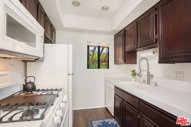 a kitchen with sink a stove and cabinets