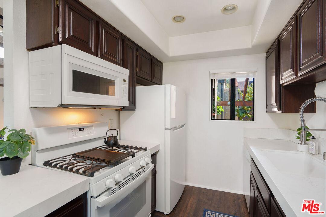 8114 Manitoba Street, Unit 208 Playa del Rey, CA 90293 - Photo 8 of 27 a kitchen with stainless steel appliances a stove a microwave a sink a refrigerator and cabinets