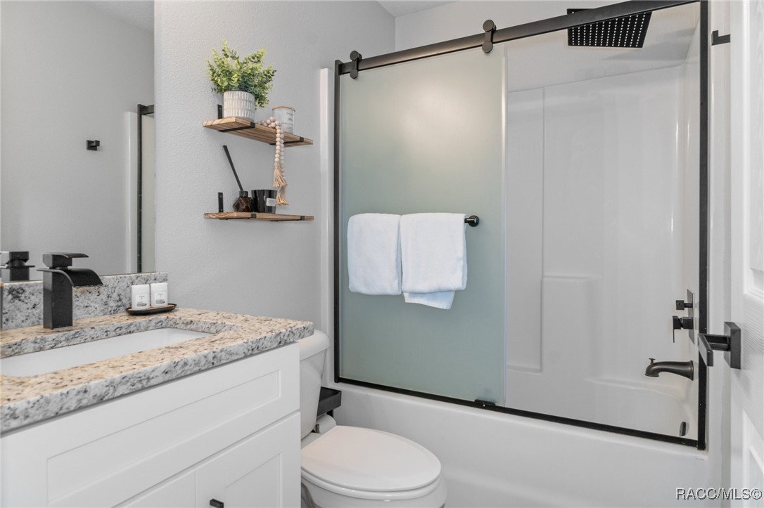 4865 South Tromp Loop Homosassa, FL 34448 - Photo 16 of 30 a bathroom with a granite countertop sink toilet and shower