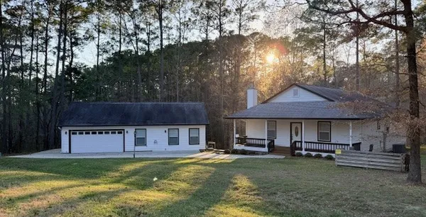 a view of a house with a yard and sitting area
