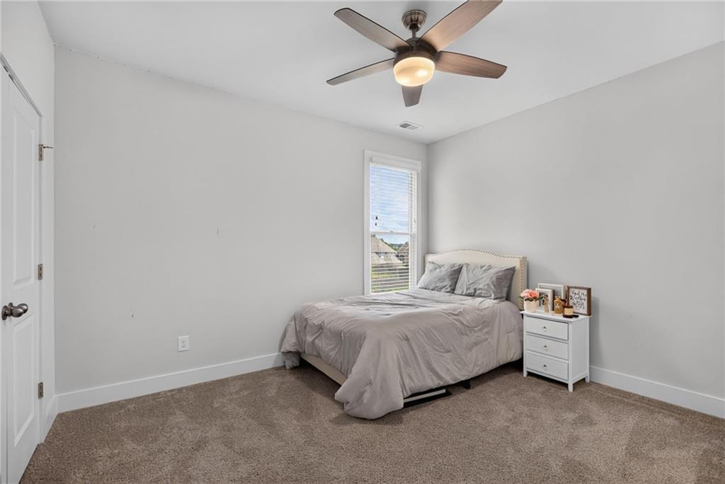 139 Manchester Lane Villa Rica, GA 30180 - Photo 40 of 60 a room with a bed and a ceiling fan