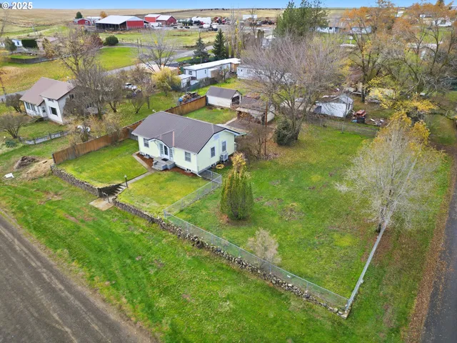 an aerial view of a house with a garden and lake view