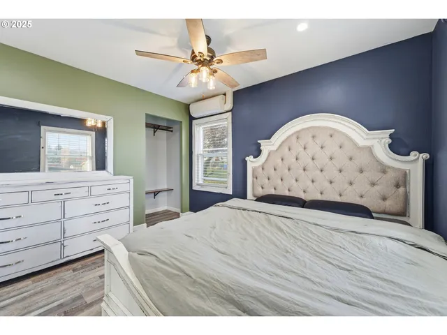 a view of a bedroom with wooden floor and cabinet
