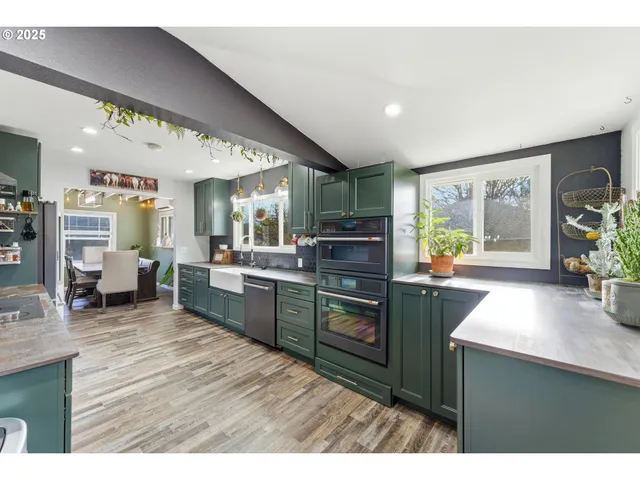 a kitchen with stainless steel appliances granite countertop sink stove top oven and cabinets