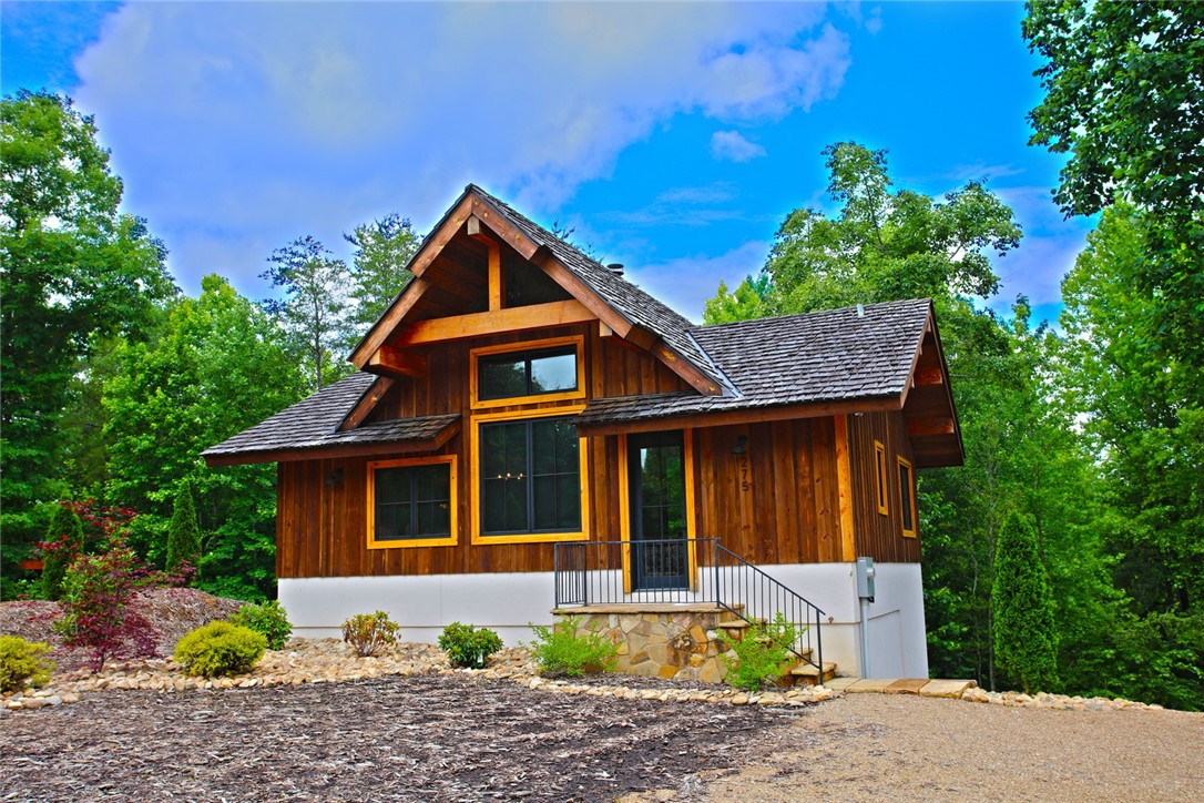 This charming cabin-style home features a warm wooden exterior and striking roof.