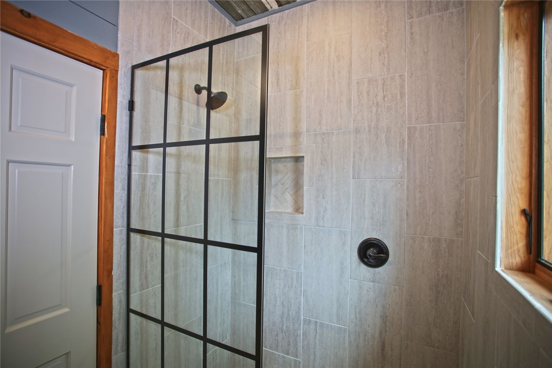 275 Jocassee Lake Road Salem, SC 29676 - Photo 14 of 41 This modern bathroom features a tiled shower with a sleek glass enclosure.
