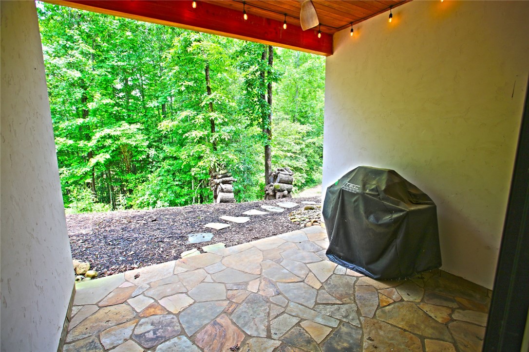 275 Jocassee Lake Road Salem, SC 29676 - Photo 28 of 41 This tranquil patio offers a peaceful retreat with natural stone flooring and lush tree views.
