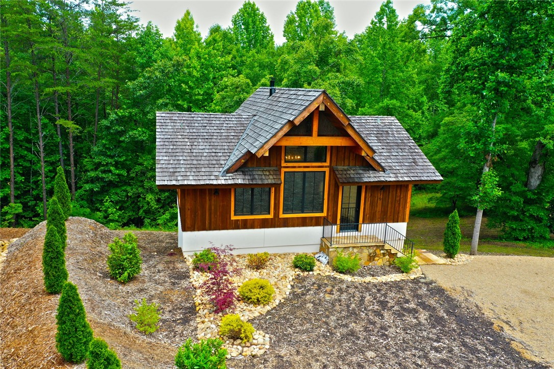 275 Jocassee Lake Road Salem, SC 29676 - Photo 34 of 41 This charming home features a wooden exterior and a stone foundation, nestled among lush trees.