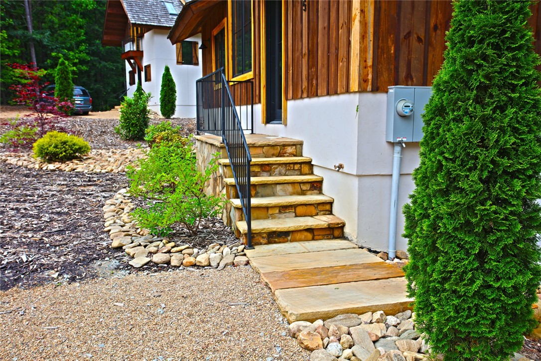 275 Jocassee Lake Road Salem, SC 29676 - Photo 4 of 41 This beautiful exterior features natural wood siding and stone stairs, complemented by a serene landscape.