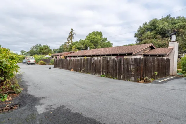 a view of a street with wooden fence