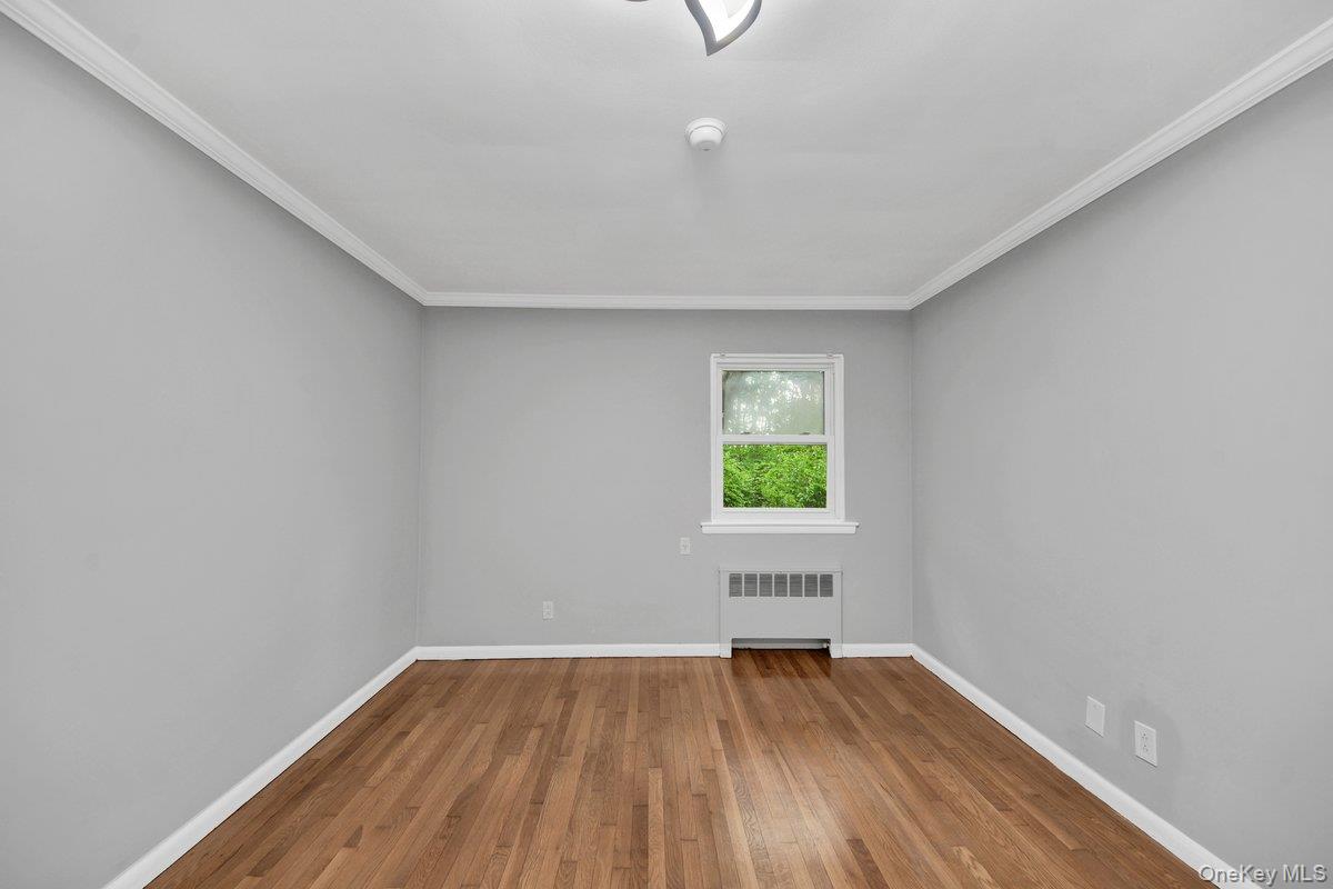 7 Rutledge Road Valhalla, NY 10595 - Photo 13 of 37 Room featuring wood-finish flooring, light grey walls, white baseboards, and crown molding