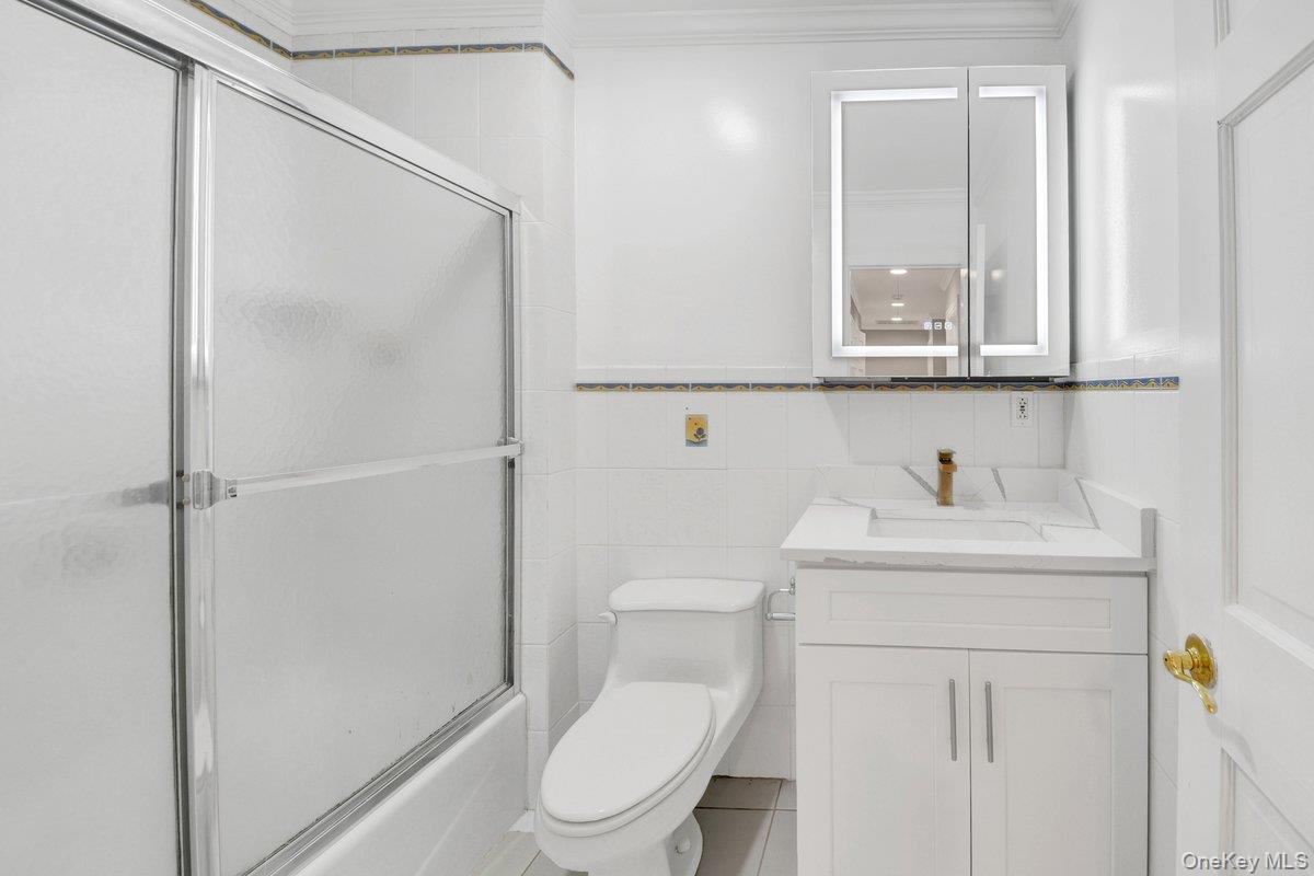 7 Rutledge Road Valhalla, NY 10595 - Photo 15 of 37 Bathroom featuring a white vanity with integrated sink, gold-tone faucet, and an illuminated mirrored medicine cabinet