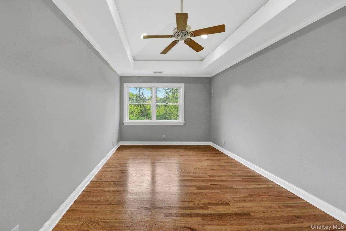 7 Rutledge Road Valhalla, NY 10595 - Photo 16 of 37 Spacious room featuring wood-finish flooring, a tray ceiling with a ceiling fan, and large windows