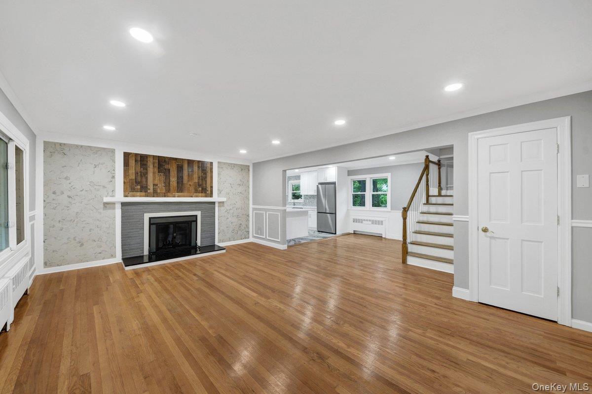 7 Rutledge Road Valhalla, NY 10595 - Photo 9 of 37 Living area featuring wood-finish flooring, recessed lighting, and a fireplace with a dark tile surround and wood plank accent