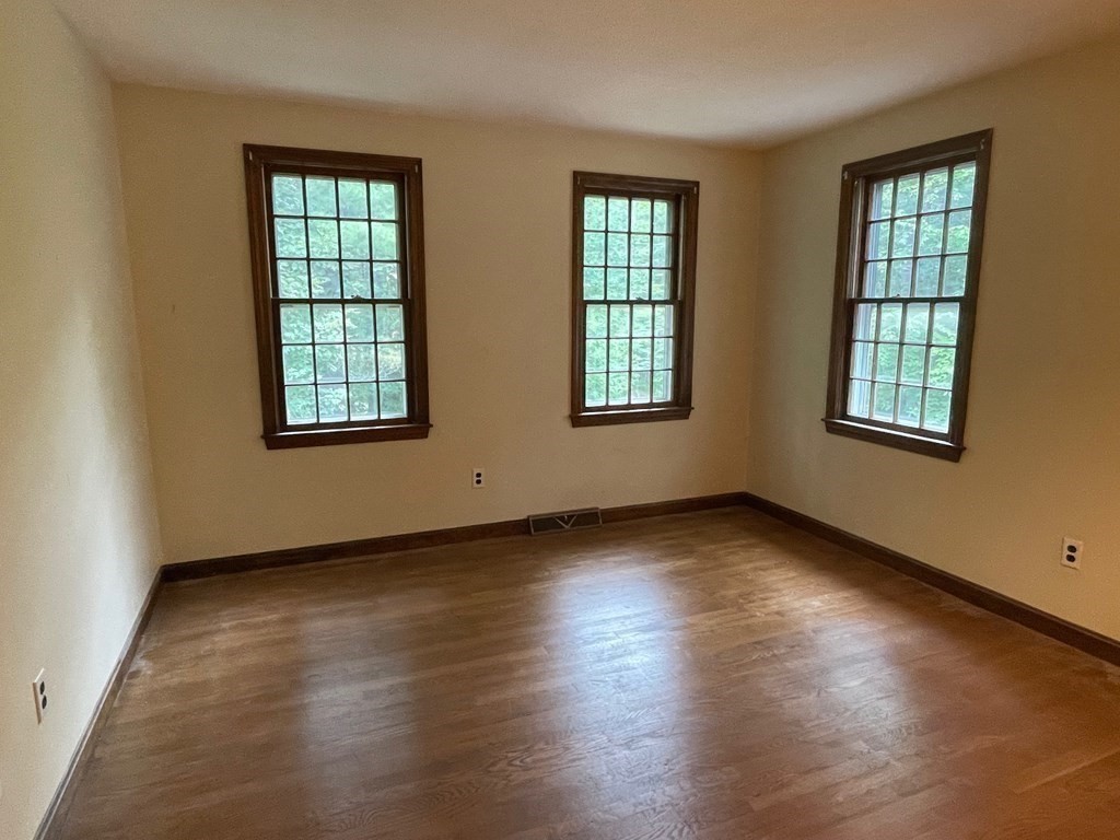 95 Hill Road Groton, MA 01450 - Photo 25 of 34 an empty room with wooden floor and windows