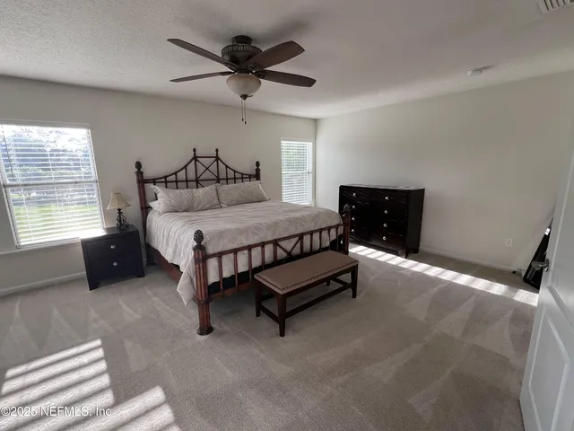 a bedroom with a bed and a ceiling fan