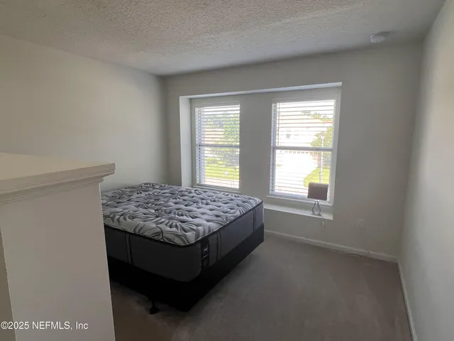 a bed sitting in a bedroom next to a window