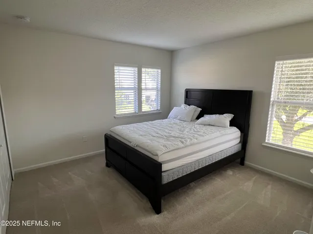 a bed sitting in a bedroom next to a window