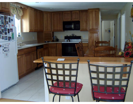 4 Plains Road Ipswich, MA 01938 - Photo 10 of 17 a kitchen with stainless steel appliances a dining table and chairs