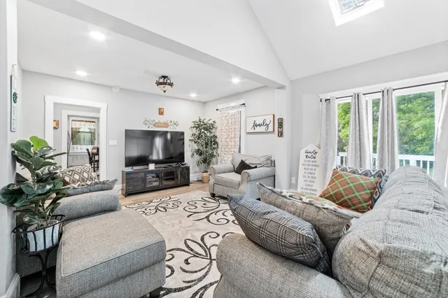 a bedroom with a bed a couch and a flat screen tv