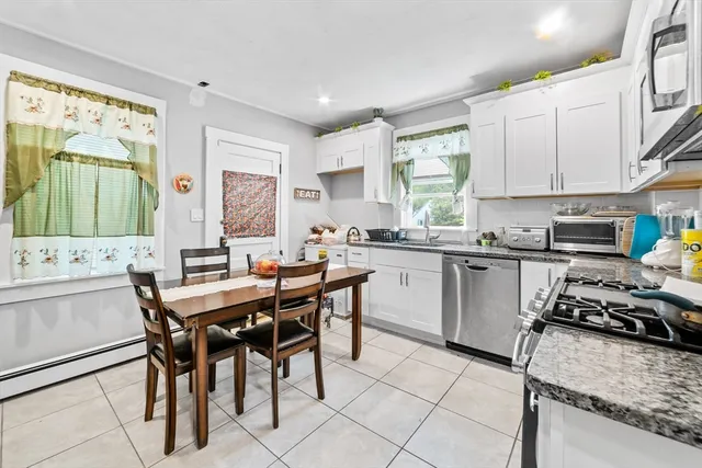 a kitchen with a stove a sink a dining table and chairs