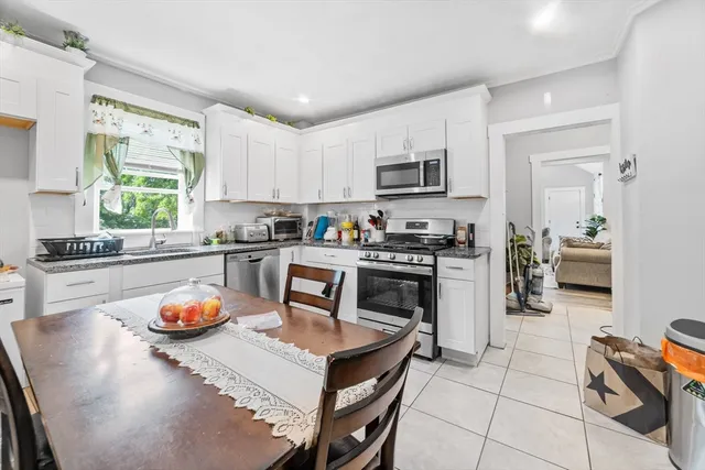 a kitchen with stainless steel appliances kitchen island granite countertop a stove a sink dishwasher and a microwave with wooden cabinets