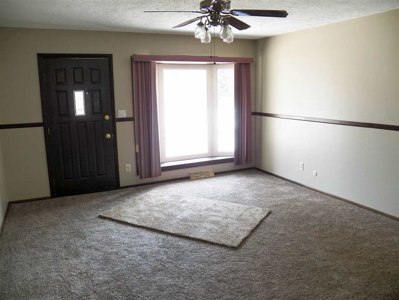 2325 Forest View Road Rockford, IL 61108 - Photo 14 of 17 an empty room with windows and chandelier fan