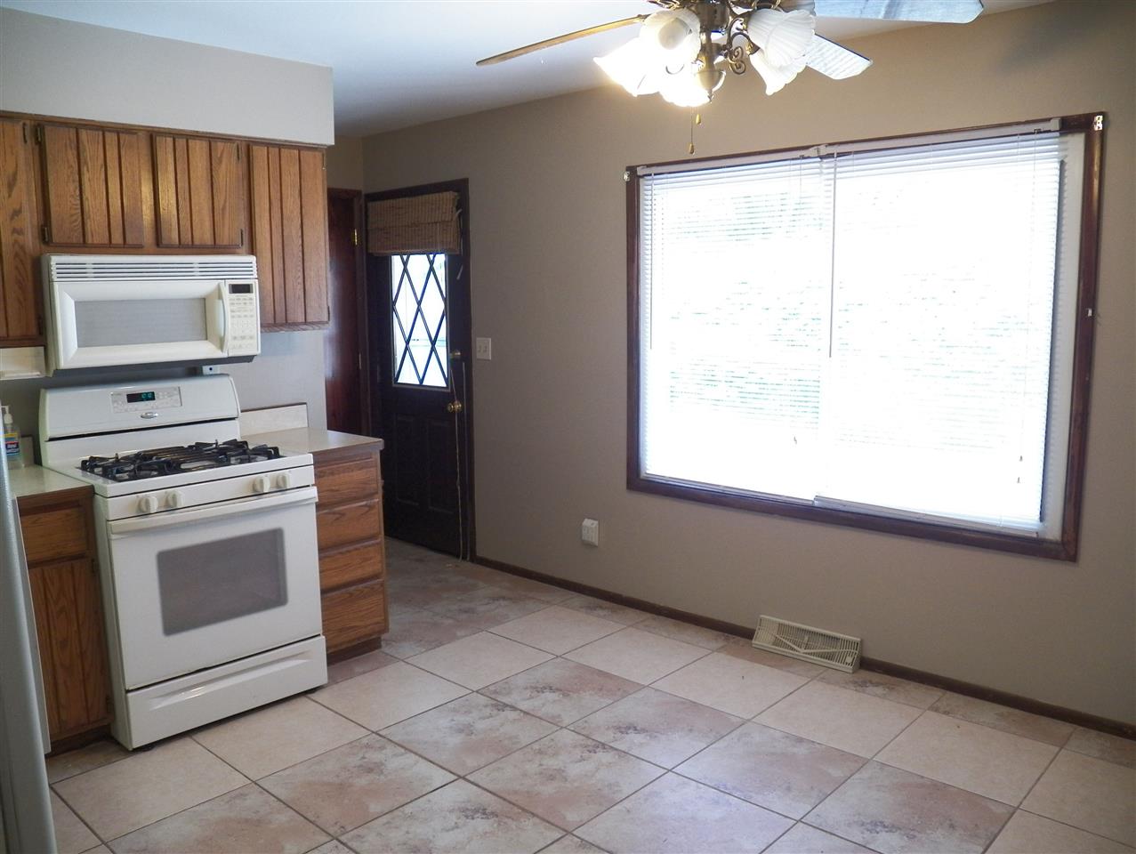 2325 Forest View Road Rockford, IL 61108 - Photo 6 of 17 a kitchen with a stove a sink and a window
