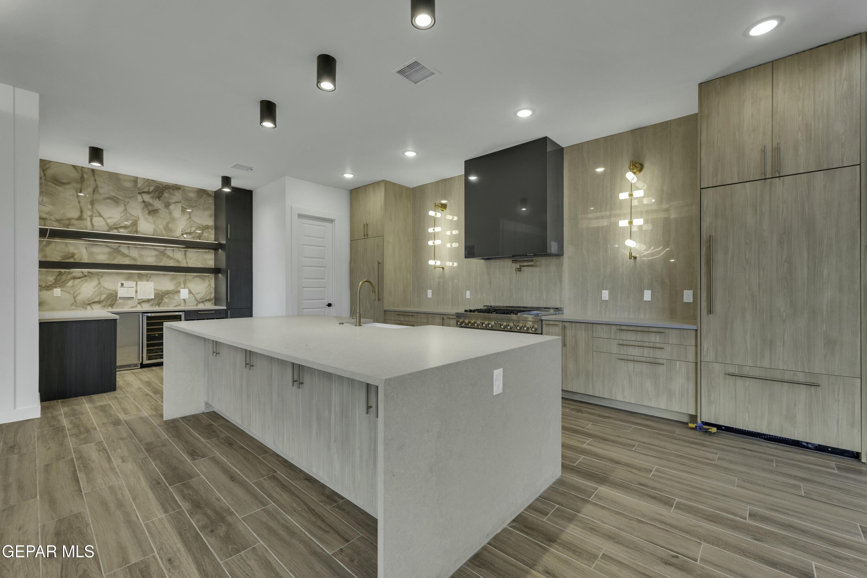884 West Gate El Paso, TX 79932 - Photo 5 of 10 a large kitchen with stainless steel appliances kitchen island a large counter top and a stove top oven