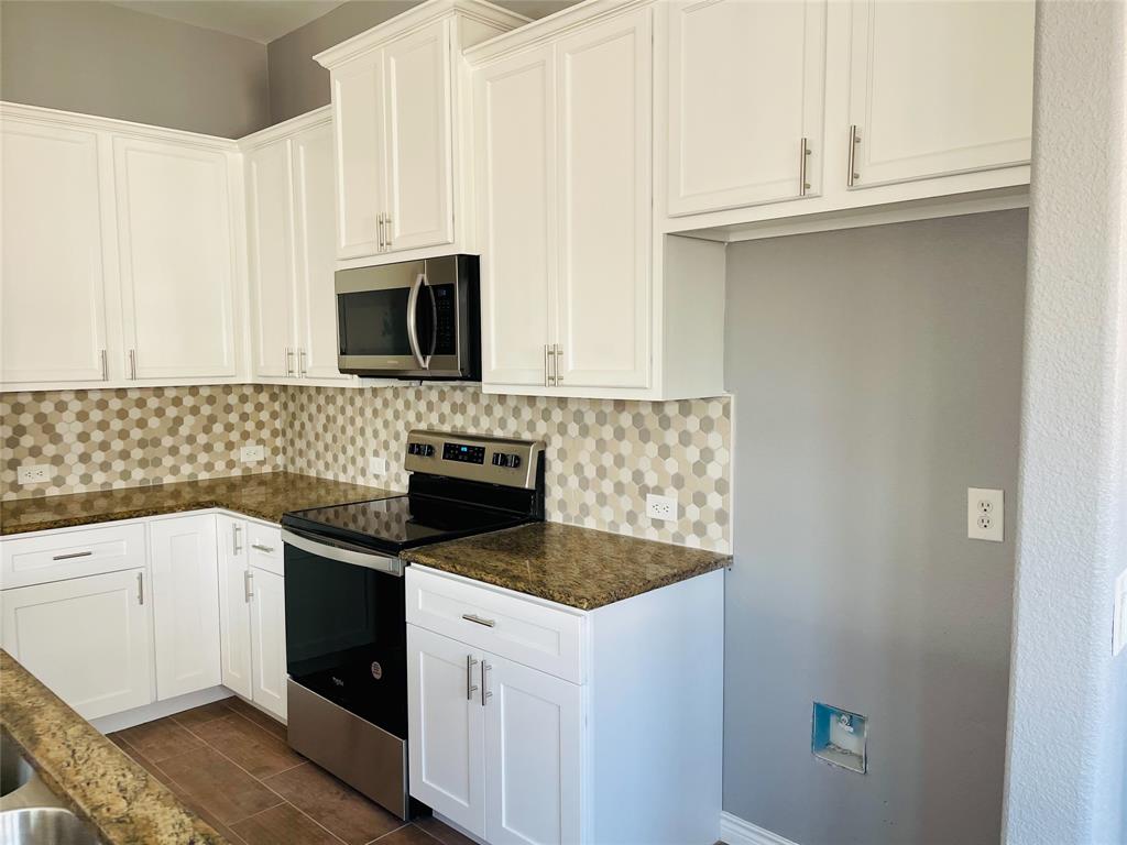 548 Kerry Street Crowley, TX 76036 - Photo 7 of 35 a kitchen with granite countertop white cabinets and black appliances