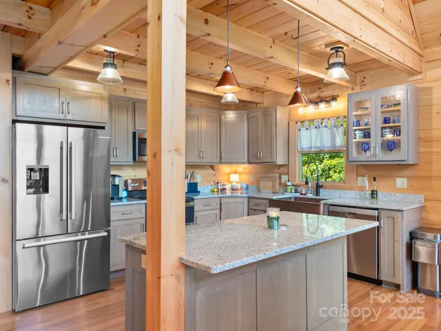 a kitchen with stainless steel appliances granite countertop a sink and a refrigerator