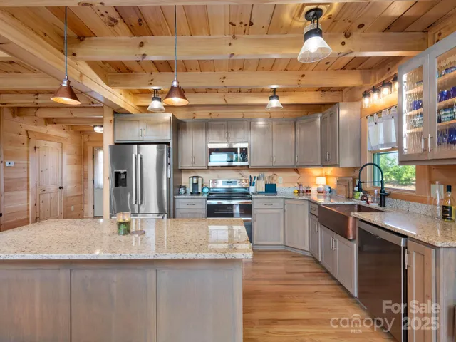 a kitchen with stainless steel appliances granite countertop a sink a stove and cabinets