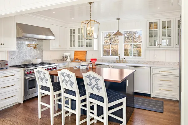 a kitchen with a stove a sink and a wooden floors