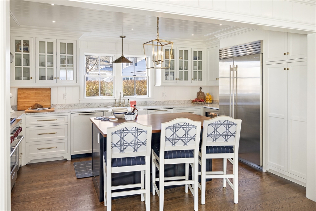 114 North Water Street Edgartown, MA 02539 - Photo 13 of 42 a kitchen with granite countertop a table chairs stove and cabinets