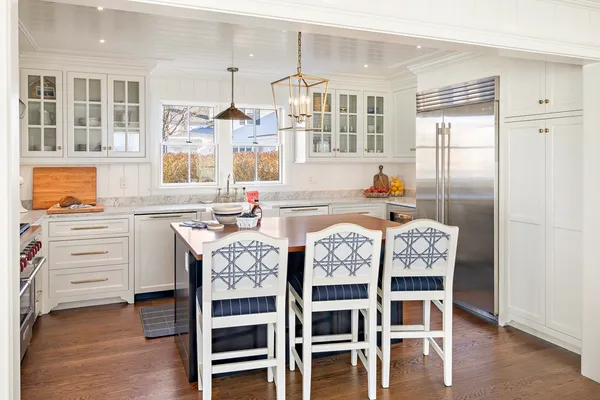 a kitchen with granite countertop a table chairs stove and cabinets