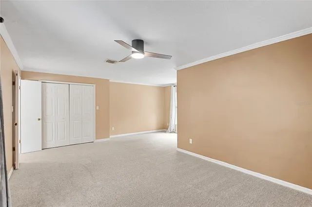 an empty room with a ceiling fan and a window
