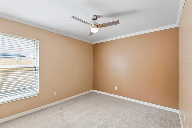 an empty room with a window and a ceiling fan