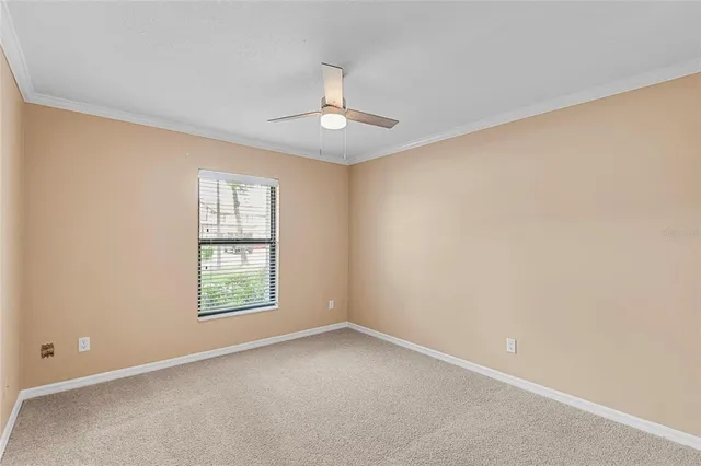 an empty room with a window and ceiling fan