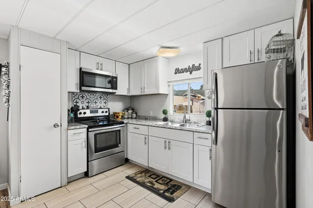 a kitchen with stainless steel appliances granite countertop a refrigerator stove a sink and a microwave