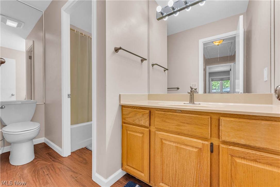 6821 Thornapple Road Gates Mills, OH 44040 - Photo 25 of 42 Bathroom featuring a wood-finish vanity with a light-toned countertop, an integrated sink, a large wall mirror, and overhead strip lighting