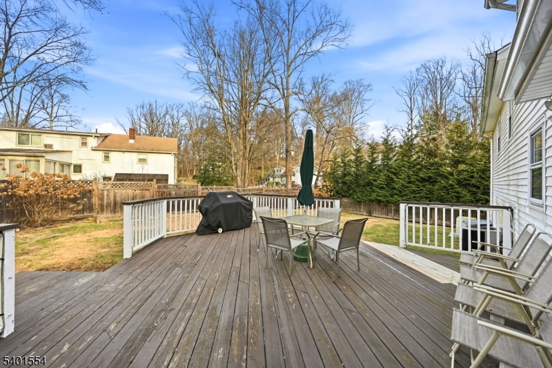 58 Dogwood Road Morristown, NJ 07960 - Photo 42 of 44 a view of a roof deck with table and chairs a barbeque with wooden floor and fence