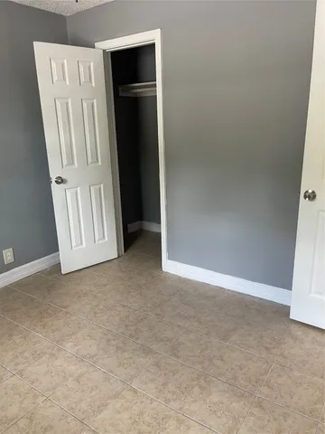 an empty room with windows and cabinet