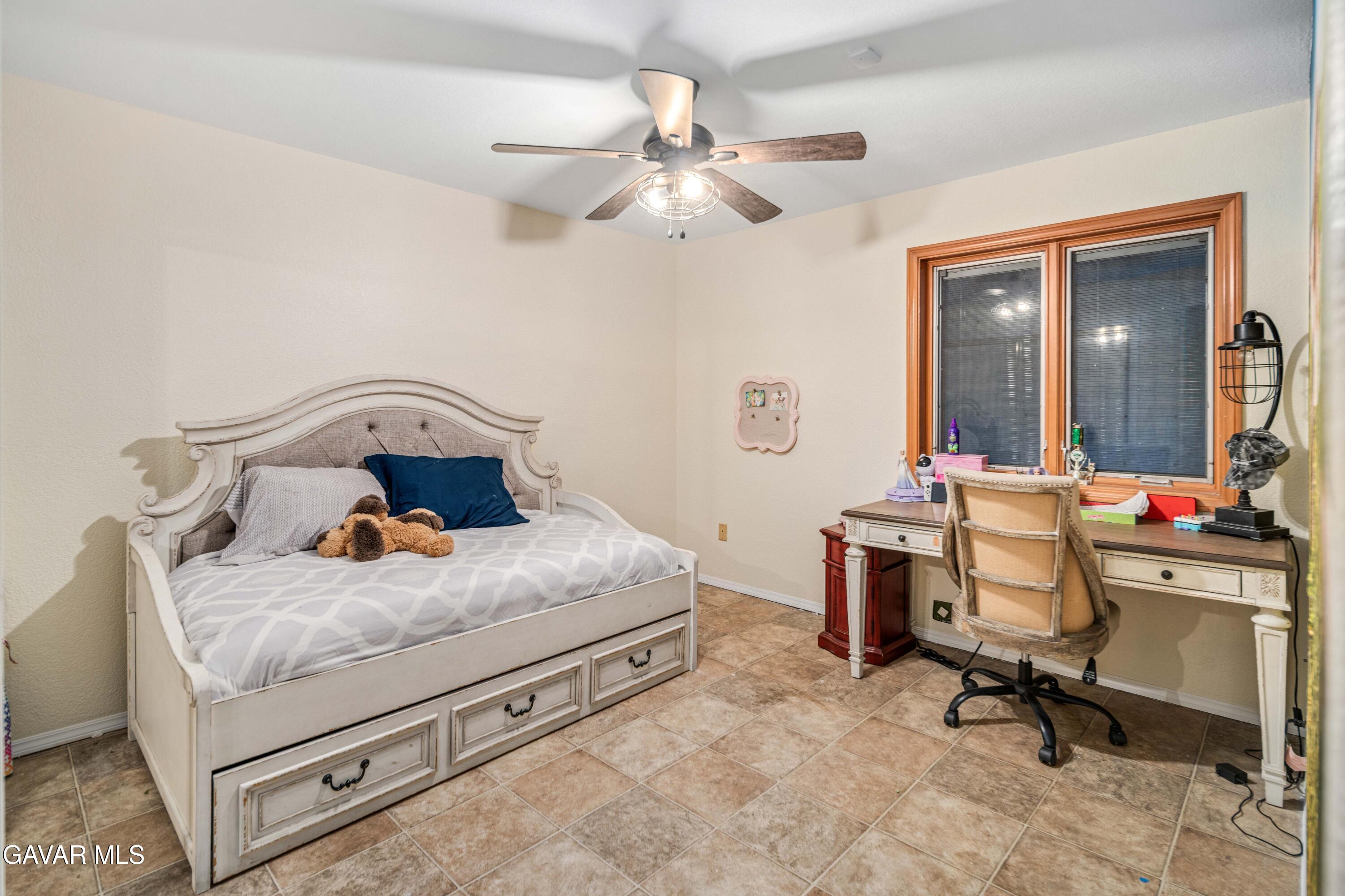 23800 Bertram Circle Tehachapi, CA 93561 - Photo 56 of 85 a bedroom with a bed and a chandelier