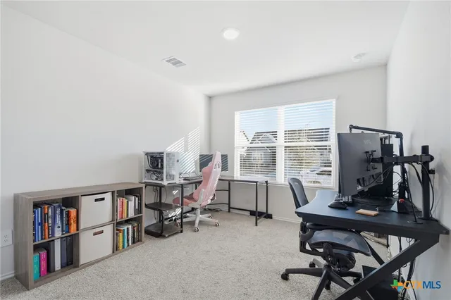 a view of a workspace with furniture and a window