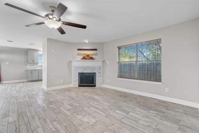 a view of an empty room with a fireplace and a window
