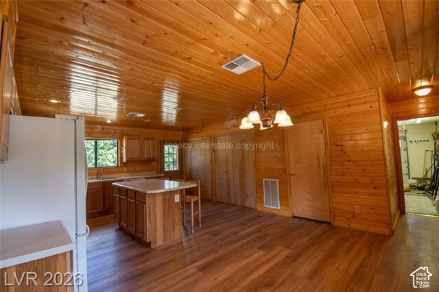1129 Ponderosa Road, Unit 40 Hatch, UT 84735 - Photo 13 of 47 Wood-paneled walls and ceiling, wood-finish flooring, kitchen island with countertop, and cabinet storage