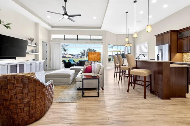 a dining hall with stainless steel appliances granite countertop wooden floor a dining table and chairs